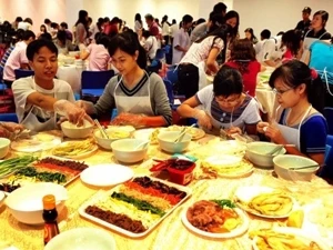 Youngsters learn to cook Korean food. Photo: VNA